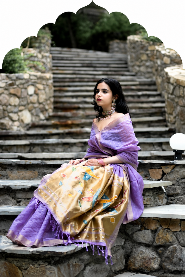 Woman in lavender and gold handwork saree seated on stone steps - Handwork Sarees collection
